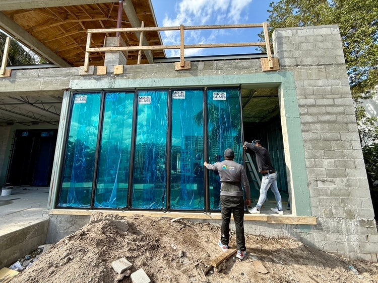 SunStorm crew installing floor-to-ceiling impact glass wall — 2412 Delmar Pl, Fort Lauderdale