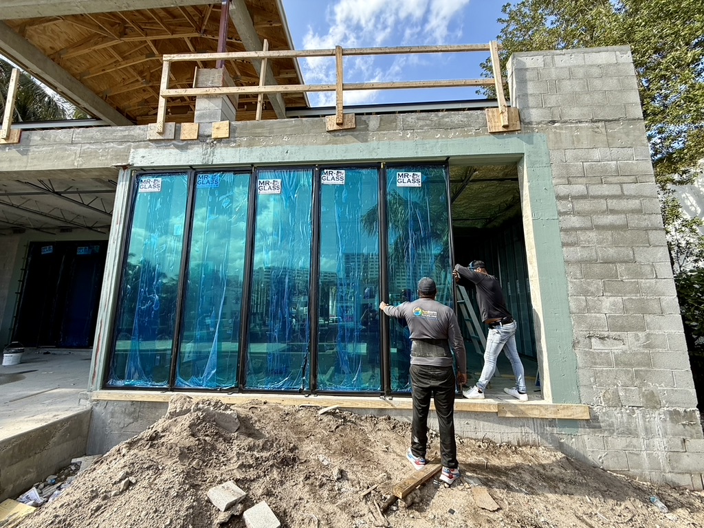 SunStorm crew installing floor-to-ceiling impact glass wall — 2412 Delmar Pl, Fort Lauderdale